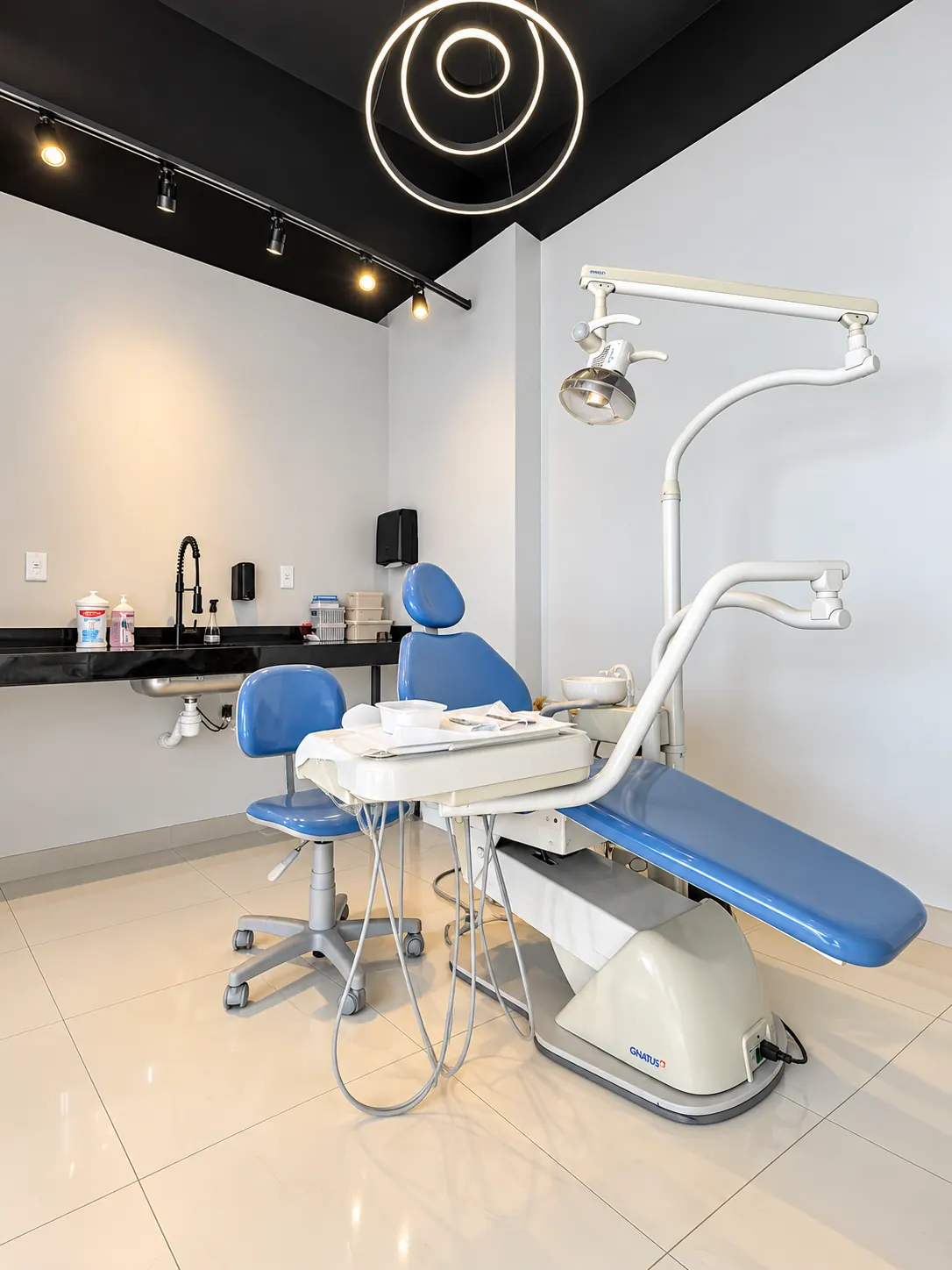 Consultório com cadeira azul e luminária circular