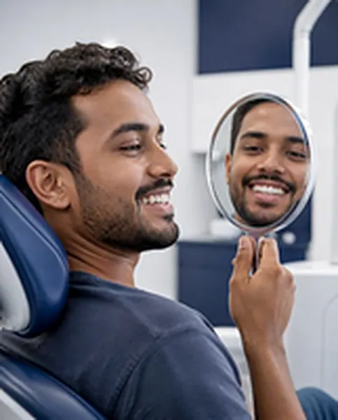 Jovem sorrindo para o espelho na cadeira do dentista