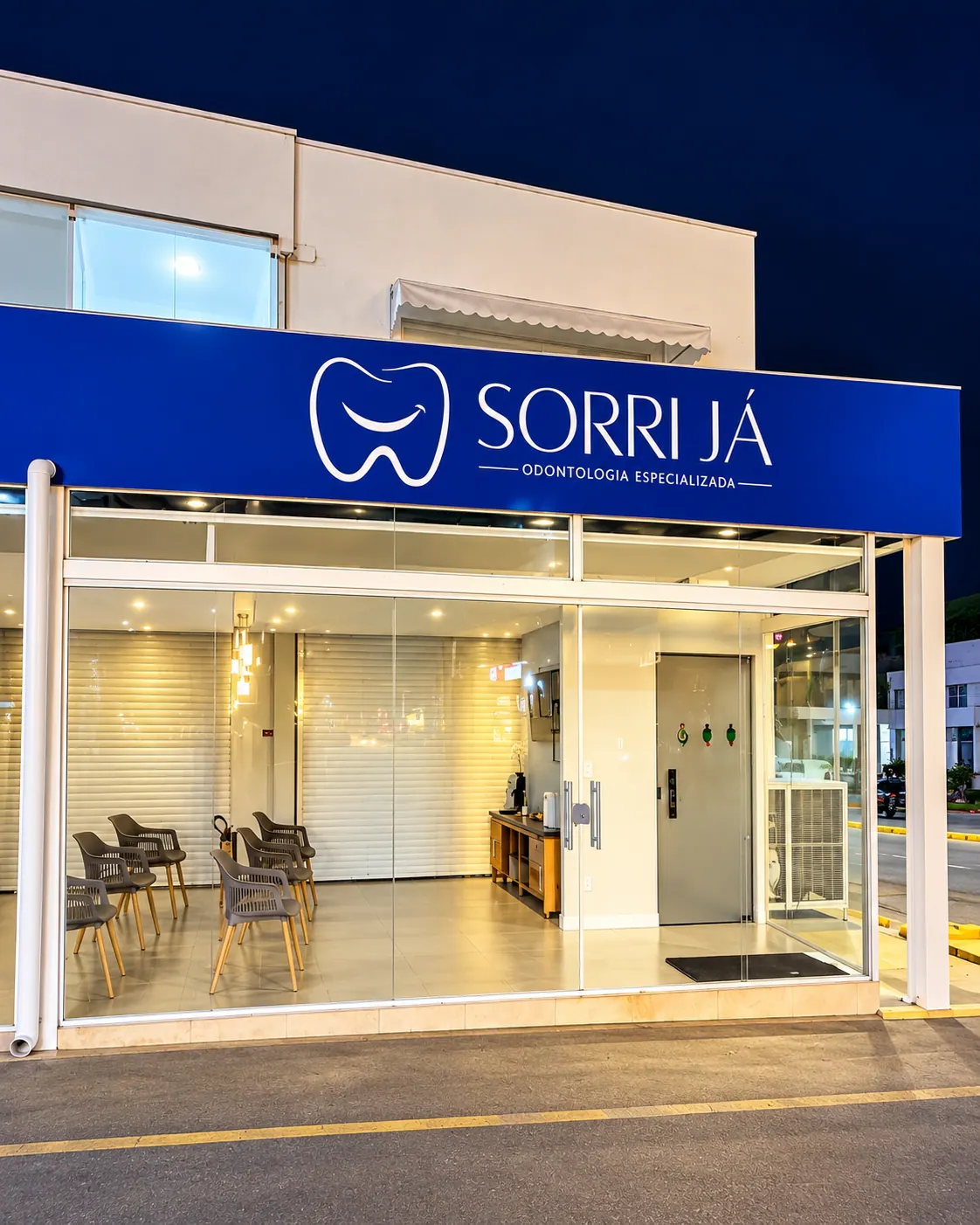 Fachada noturna da Sorri Já com o letreiro iluminado